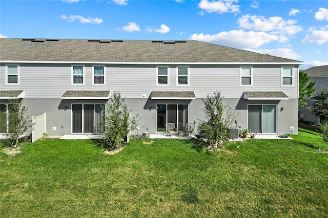 rear view of house featuring a lawn and a sunroom