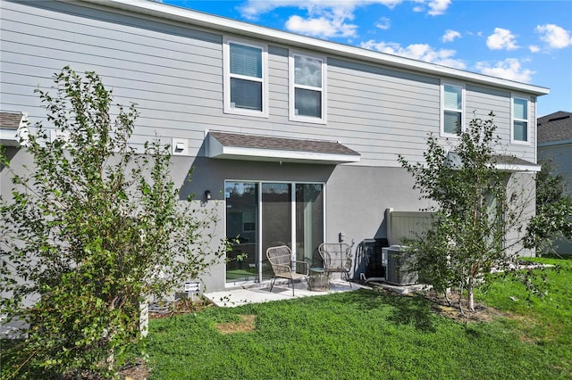 back of property with a patio and a lawn