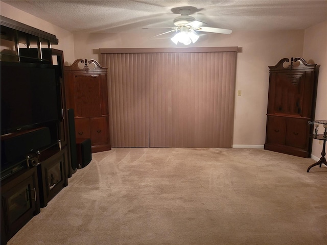 living room featuring ceiling fan, light colored carpet, and a textured ceiling