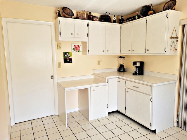 kitchen featuring light tile patterned floors and white cabinets