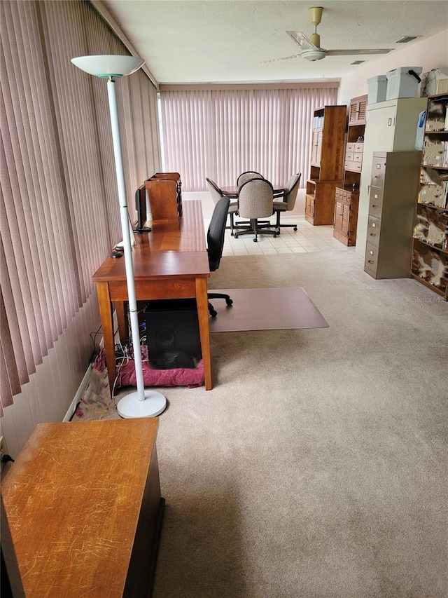 carpeted office space with ceiling fan