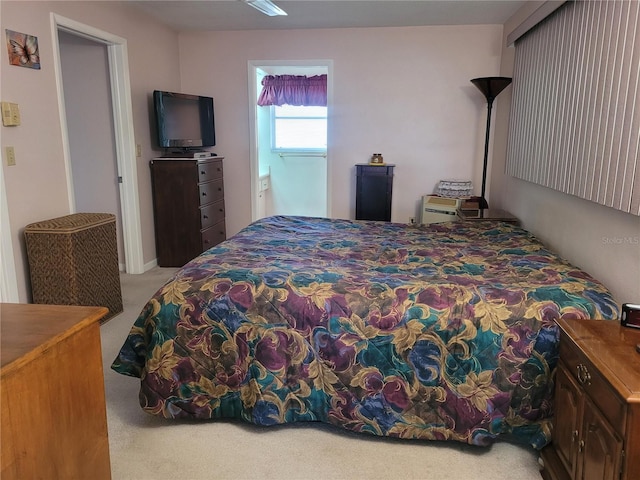 bedroom featuring connected bathroom and light carpet