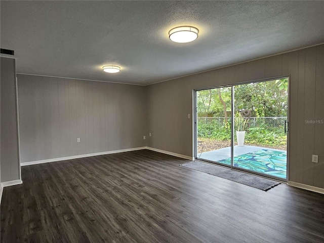 spare room with dark hardwood / wood-style flooring and a textured ceiling