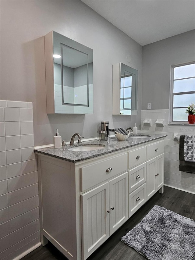 bathroom with tile walls, hardwood / wood-style floors, and vanity