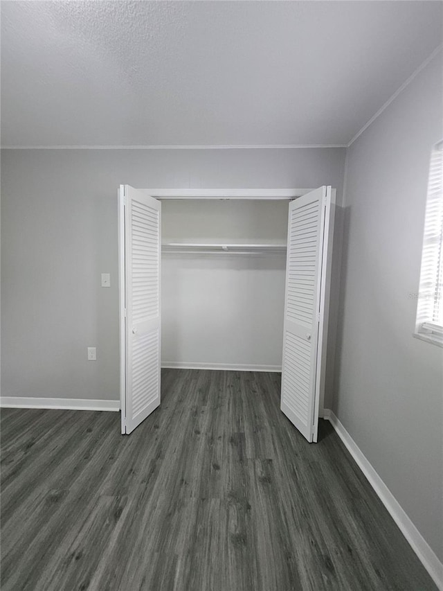 unfurnished bedroom featuring a closet and dark hardwood / wood-style floors