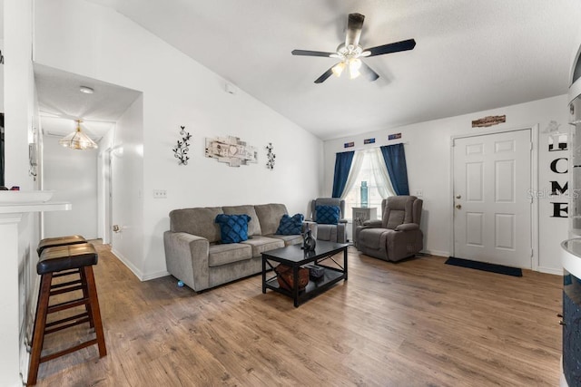 living room with hardwood / wood-style floors, lofted ceiling, and ceiling fan