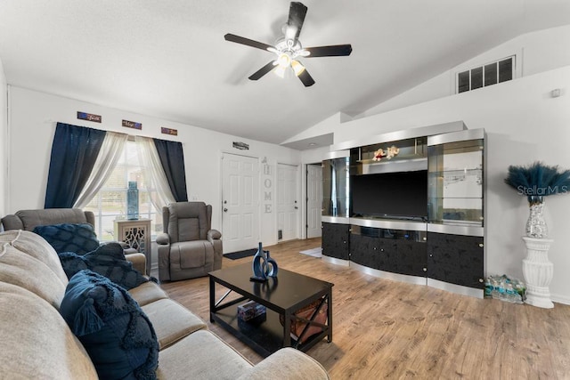 living room featuring hardwood / wood-style flooring, ceiling fan, and vaulted ceiling