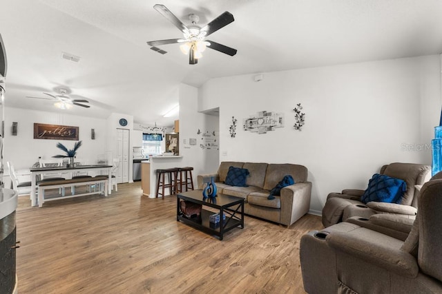 living room featuring wood-type flooring, ceiling fan, and vaulted ceiling