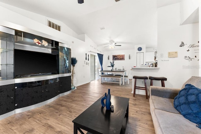 living room with hardwood / wood-style floors, vaulted ceiling, and ceiling fan