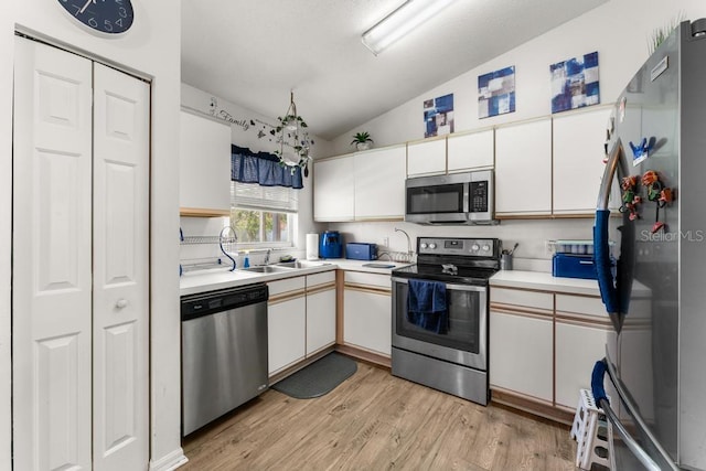 kitchen featuring white cabinetry, appliances with stainless steel finishes, sink, and light hardwood / wood-style flooring