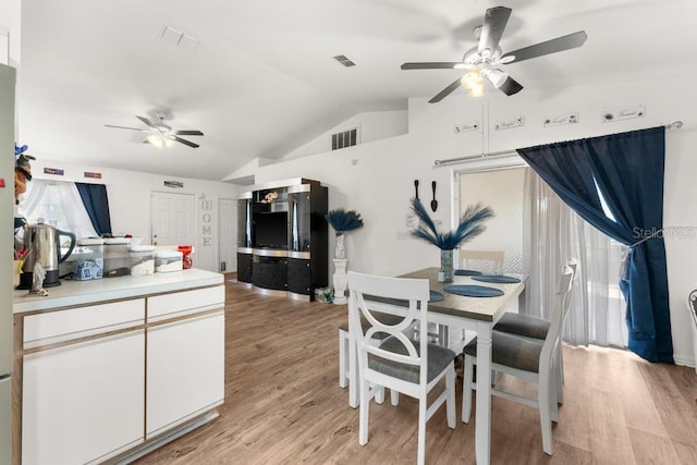 dining area with light hardwood / wood-style floors, ceiling fan, and lofted ceiling