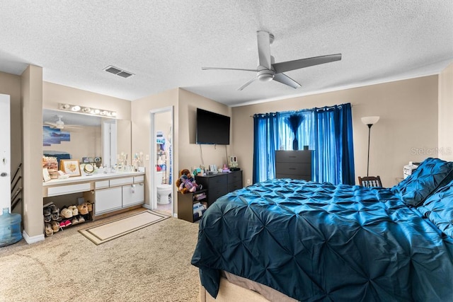 carpeted bedroom with connected bathroom, a textured ceiling, and ceiling fan