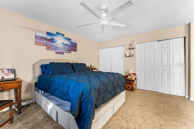 bedroom with carpet, ceiling fan, and two closets