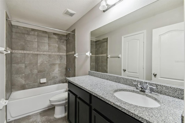 full bathroom with tile patterned floors, toilet, tiled shower / bath, a textured ceiling, and vanity