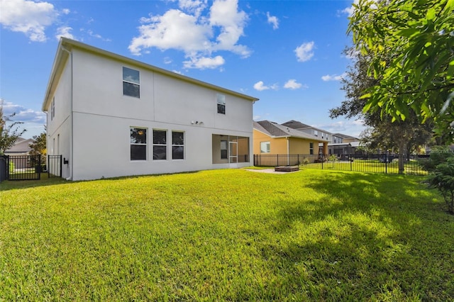 rear view of house featuring a yard