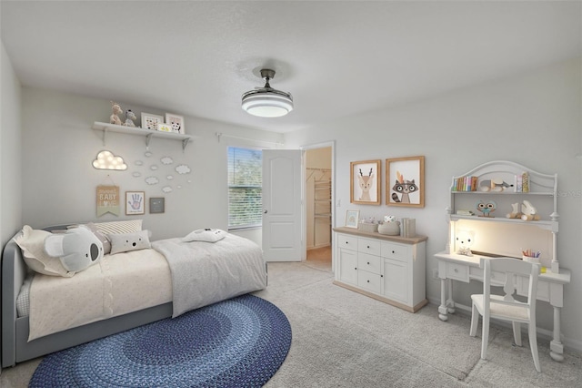 carpeted bedroom with a closet and a spacious closet