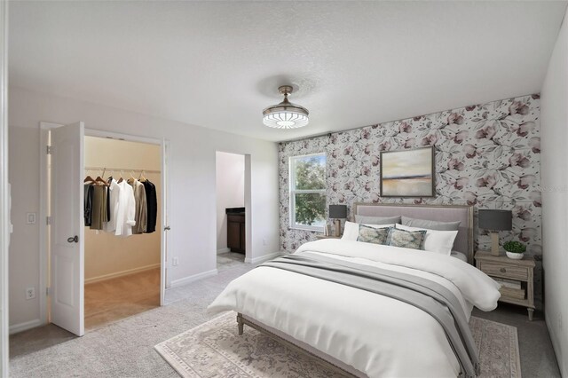 carpeted bedroom featuring a closet and a walk in closet