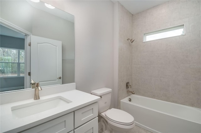 full bathroom featuring vanity, toilet, a healthy amount of sunlight, and tiled shower / bath combo