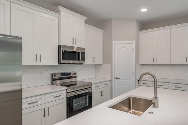 kitchen featuring sink, white cabinets, stainless steel appliances, and backsplash