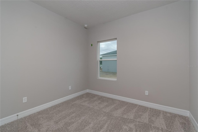 carpeted empty room featuring a textured ceiling