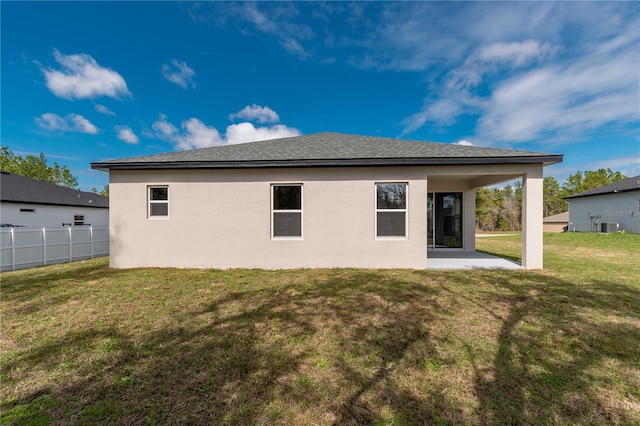 rear view of house featuring a patio, a yard, stucco siding, central AC unit, and fence