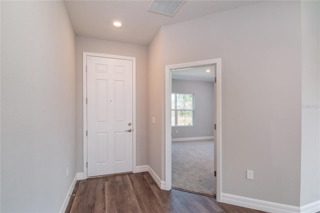 doorway to outside featuring baseboards, visible vents, and dark wood-style flooring