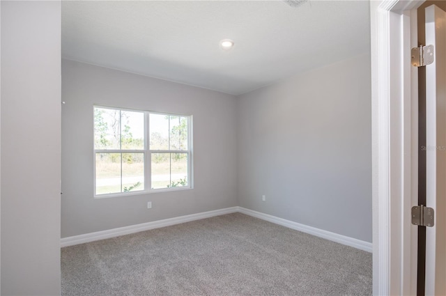 carpeted spare room featuring baseboards