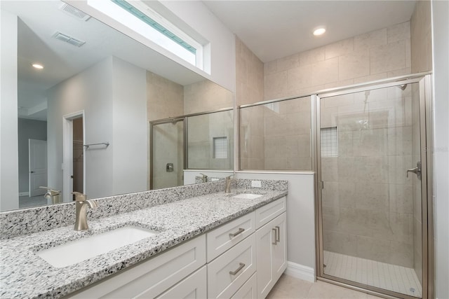 bathroom with double vanity, a stall shower, visible vents, and a sink