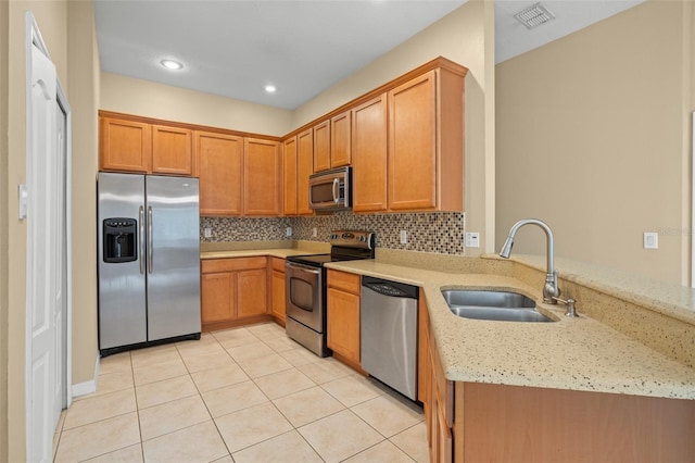 kitchen with decorative backsplash, stainless steel appliances, sink, light tile patterned flooring, and light stone counters