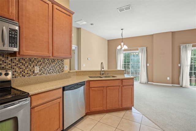 kitchen featuring decorative backsplash, light tile patterned floors, appliances with stainless steel finishes, an inviting chandelier, and sink