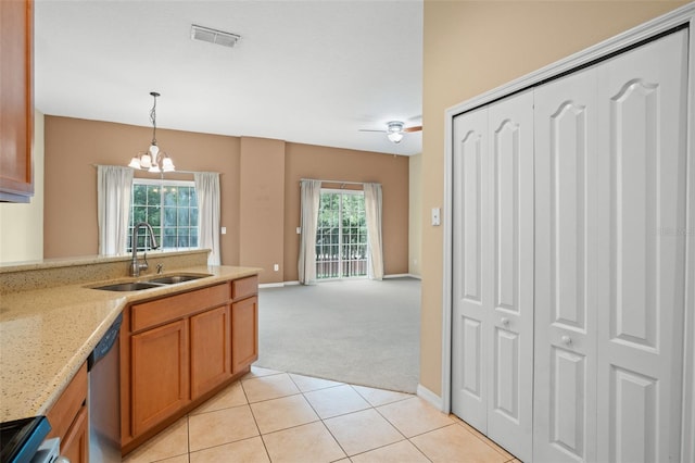 kitchen with stainless steel dishwasher, sink, ceiling fan with notable chandelier, decorative light fixtures, and light colored carpet