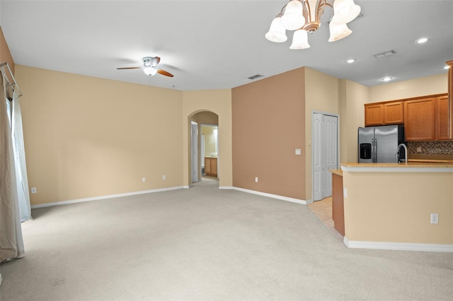 kitchen featuring stainless steel fridge, hanging light fixtures, light colored carpet, and backsplash