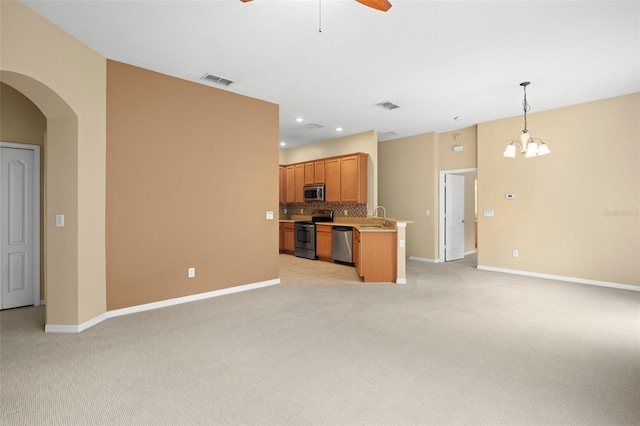 kitchen featuring decorative backsplash, stainless steel appliances, sink, pendant lighting, and light colored carpet