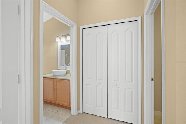 hallway with sink and light tile patterned floors