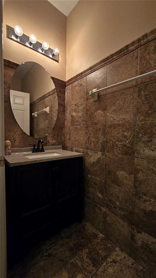 bathroom with vanity and tile walls