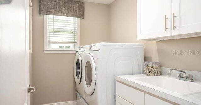 laundry room featuring cabinets, sink, and washing machine and clothes dryer