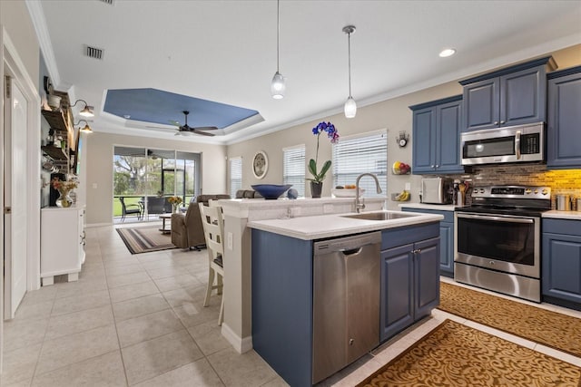 kitchen with blue cabinetry, sink, light tile patterned flooring, and appliances with stainless steel finishes