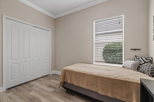 bedroom featuring crown molding, a closet, and light hardwood / wood-style flooring