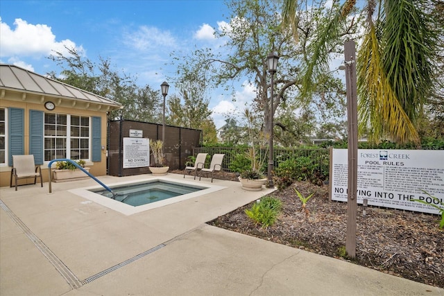 view of swimming pool featuring a patio area and a hot tub