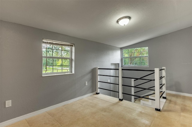 tiled bedroom with multiple windows and vaulted ceiling