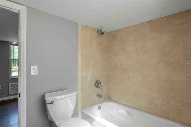 bathroom featuring toilet, tiled shower / bath, and hardwood / wood-style floors