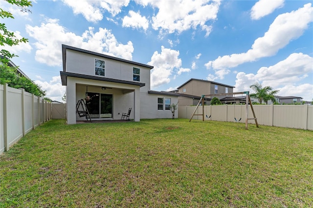 back of property with a yard and a patio