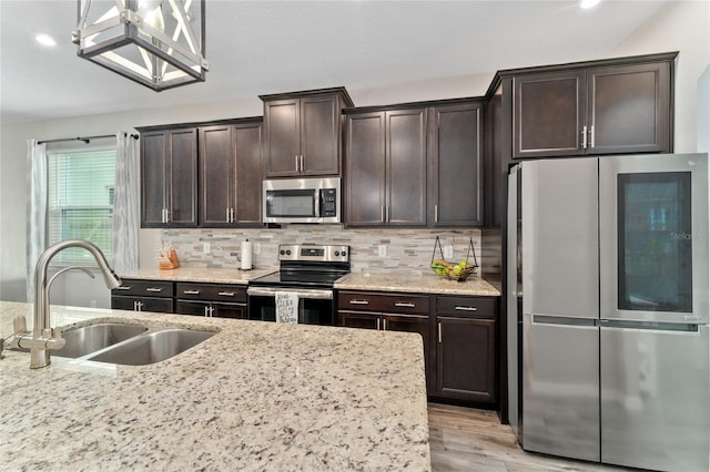 kitchen with sink, backsplash, dark brown cabinets, light hardwood / wood-style floors, and stainless steel appliances