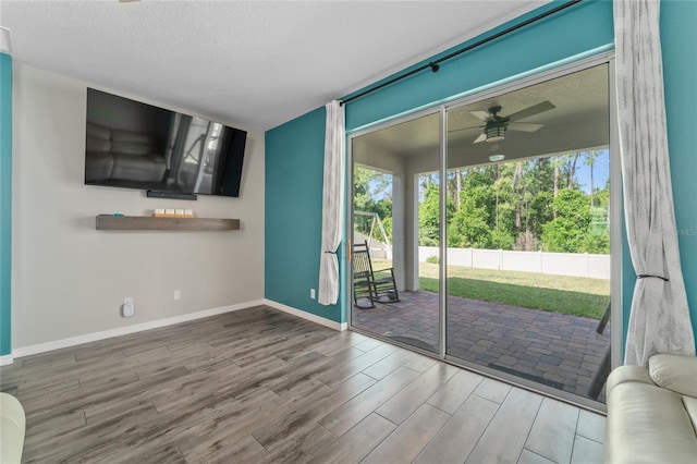 living room with ceiling fan, hardwood / wood-style flooring, and a textured ceiling