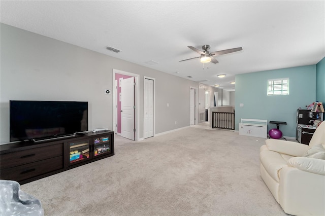 living room featuring light carpet and ceiling fan