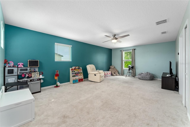 playroom with a textured ceiling, carpet floors, and ceiling fan