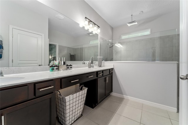 bathroom featuring vanity, tile patterned floors, a textured ceiling, and tiled shower