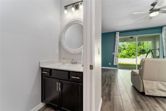 bathroom featuring vanity, a textured ceiling, hardwood / wood-style flooring, and ceiling fan