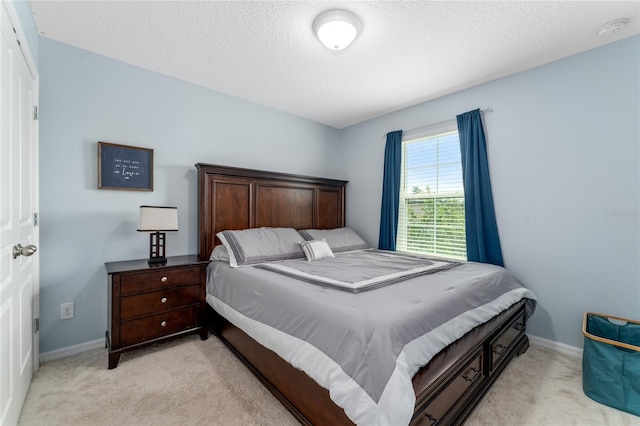 bedroom with light carpet and a textured ceiling