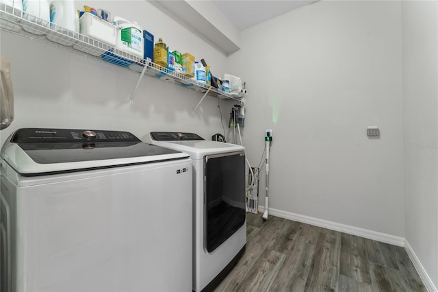 laundry room with dark wood-type flooring and washer and dryer